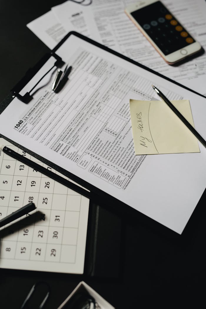 services-01 Close-up view of a neatly organized desk with tax forms, calculator, and stationery for financial planning.
